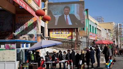 Residents line up at a security checkpoint into the Hotan Bazaar.