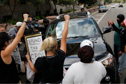 Protestors block a car with Ohio House Speaker Larry Householder.