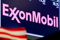 The logo for ExxonMobil appears above a trading post on the floor of the New York Stock Exchange.
