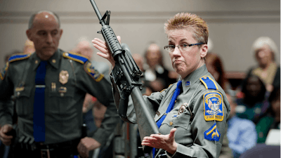 Firearms training unit Detective Barbara J. Mattson, of the Connecticut State Police, holds up a Bushmaster AR-15 rifle.