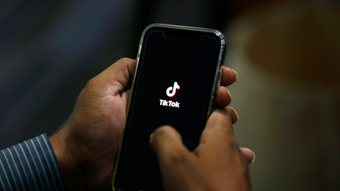In this July 21, 2020 file photo, a man opens social media app 'TikTok' on his cell phone, in Islamabad, Pakistan. Walmart said Thursday, Aug. 27, that it's interested in teaming up with Microsoft to buy the U.S. business of TikTok, the popular Chinese video app.