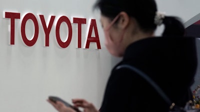 A visitor stands by the logo of Toyota Motor Corp. at its showroom in Tokyo.