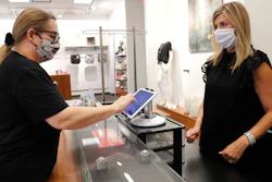 Monique Kursar, left, completes a purchase with Amy Witt, owner of the Velvet Window clothing store in Dallas, May 13, 2020.