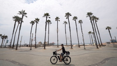 A cyclist rides through the pier plaza in Huntington Beach, Calif.