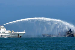 A rescue vessel tries to put out fire emerging from an oil tanker.