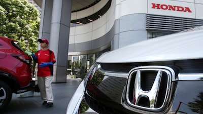 Employee of Honda Motor Co. cleaning a Honda car displayed at its headquarters in Tokyo.