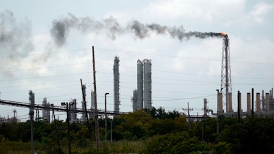 Winds blow the smoke from a refinery.