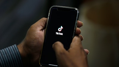 A man opens social media app 'TikTok' on his cell phone.