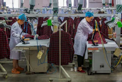 Workers iron shirts in an apparel factory.