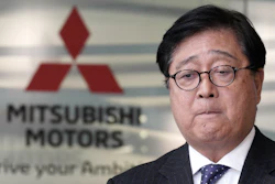 Mitsubishi Motors CEO Osamu Masuko bites his lips during a press conference.