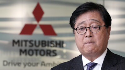 Mitsubishi Motors CEO Osamu Masuko bites his lips during a press conference.