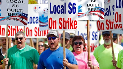 In this July 25, 2020 file photo, striking Bath Iron Works shipbuilders march in solidarity in Bath, Maine. A 63-day strike at Bath Iron Works — against the backdrop of a pandemic in an election year — came to an end Sunday, Aug. 23 with shipbuilders voting to return to their jobs producing warships for the United States Navy.