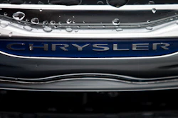 In this Dec. 2, 2014 file photo, a Chrysler minivan sits under rain at a car lot in San Diego. The U.S. government’s road safety agency, on Monday, Aug. 10, 2020, is investigating complaints of fires in a power and charging port in some Chrysler Town and Country minivans. The National Highway Traffic Safety Administration says it has three reports of fires and one injury in minivans from the 2014 model year.