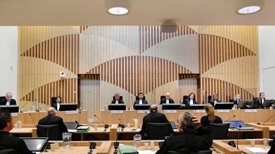Presiding judge Hendrik Steenhuis, rear fifth from right, opens the court session as the trial resumed for three Russians and a Ukrainian charged with crimes including murder for their alleged roles in the shooting down of Malaysia Airlines Flight MH17 over eastern Ukraine in 2014, at the high security court building at Schiphol Airport, near Amsterdam, Monday, August 31, 2020. Judges and lawyers representing relatives of the 298 people killed are expected to discuss the issue of compensation.