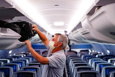 In this May 28, 2020, file photo, a passenger wears personal protective equipment on a Delta Airlines flight after landing at Minneapolis−Saint Paul International Airport, in Minneapolis. Airlines are trying to convince a frightened public that measures like mandatory face masks and hospital-grade air filters make sitting in a plane safer than many other indoor settings during the coronavirus pandemic, but it isn’t working.