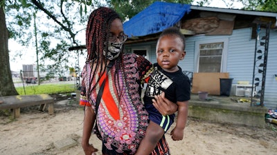 Fakisha Fenderson and her son Tyler stand in the front yard of her parent's home in Laurel, Miss.