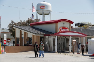 In this May 7 file photo, workers enter and leave the Tyson Foods pork processing plant in Logansport, IN.