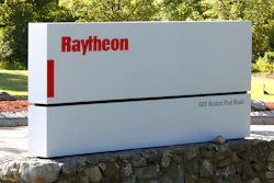 A sign stands at the road leading to the Raytheon facility.