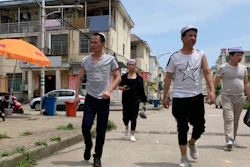 In this June 5, 2019, photo, residents of the Hui Muslim ethnic minority walk in a neighborhood near an OFILM factory in Nanchang in eastern China's Jiangxi province.