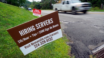 In this Wednesday, Sept. 2, 2020, file photo help wanted signs for servers and cooks at Nemacolin Woodlands Resort and Spa are displayed along route 40 at the entrance to the resort in Farmington, Pa. U.S. employers advertised more jobs but hired fewer workers in July, sending mixed signals about a job market in the wake of the coronavirus outbreak. The Labor Department said Wednesday, Sept. 9, 2020, that the number of U.S. job postings on the last day of July rose to 6.6 million from 6 million at the end of June.