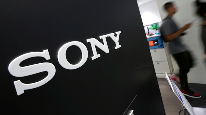 Visitors walk past a logo of Sony at Sony Building in Tokyo.