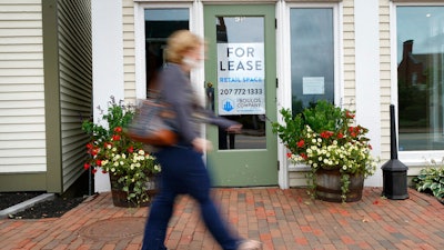 A shopper walks by one of several vacant retail spaces among the outlet shops in Freeport, Maine.