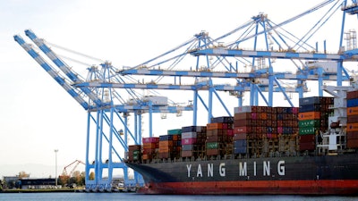 Cargo cranes are used to take containers off of a Yang Ming Marine Transport Corporation boat at the Port of Tacoma in Tacoma, Wash.