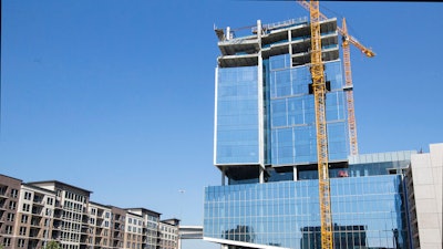 Construction workers place a tarp over an opening on the first level of the Marathon Oil building.