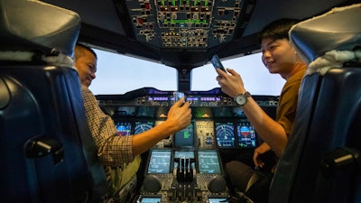 Customers take selfie photos in an Airbus A380 flight simulator.
