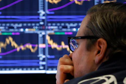 In this Jan. 28, 2020 photo, specialist Gregg Maloney watches the screens at his post on the floor of the New York Stock Exchange.