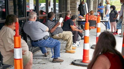 Job seekers exercise social distancing as they wait to be called into the Heartland Workforce Solutions office in Omaha, Neb.