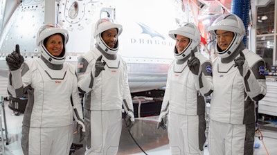 In this Thursday, Sept. 24, 2020, image released by SpaceX/NASA, NASA’s SpaceX Crew-1 astronauts, from left, mission specialist Shannon Walker, pilot Victor Glover, and Crew Dragon commander Michael Hopkins, all NASA astronauts, and mission specialist Soichi Noguchi, Japan Aerospace Exploration Agency (JAXA) astronaut, gesture during crew equipment interface testing at SpaceX headquarters in Hawthorne, Calif. SpaceX’s second astronaut flight is off until mid-November 2020 because red lacquer dripped into tiny vent holes in two rocket engines that now must be replaced.