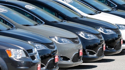 In this Wednesday, April 15, 2020 file photo, Cars are parked in an auto dealer lot in unincorporated St. Louis County, Mo. U.S. new vehicle sales fell 9.7% in the third quarter, but that's not all that bad for the auto industry. Consumers are paying record prices largely for loaded out trucks and SUVs. Discounts are down because vehicle supplies are limited. Interest rates are low.
