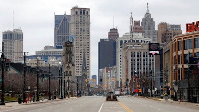 In this March 24, 2020 file photo, Woodward Avenue is shown nearly empty in Detroit. Before the coronavirus showed up, downtown Detroit was returning to its roots as a vibrant city center, motoring away from its past as the model of urban ruin. Now, with the coronavirus forcing many office workers to their homes in the suburbs, those who remain wonder if revitalization will ever return.