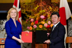British International Trade Secretary Liz Truss, left, and Japanese Foreign Minister Toshimitsu Motegi exchange agreement documents for economic partnership between Japan and Britain at Iikura Annex of the Foreign Ministry in Tokyo, Friday, Oct. 23, 2020. Japan and Britain signed a bilateral free trade deal Friday in the the first such major post-Brexit deal, reducing tariffs on Yorkshire lamb sold in Japan, as well as auto parts for Japan’s Nissan plant.