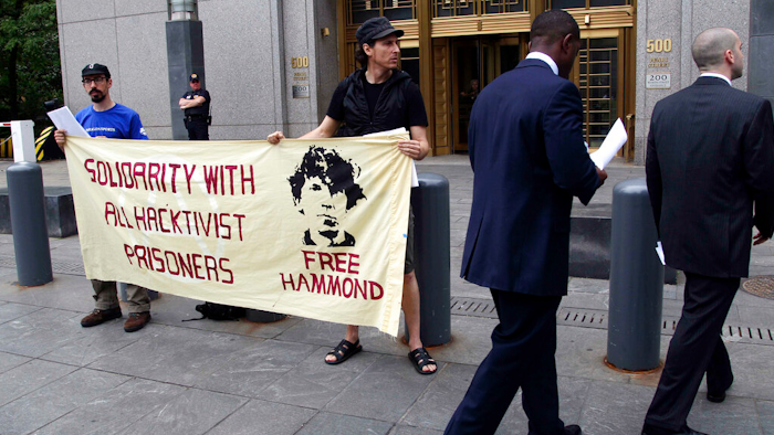 Protesters stand in front of the federal courthouse during the arraignment of hacker Jeremy Hammond, New York, May 14, 2012.