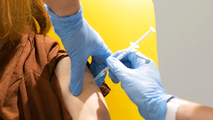 In this undated file photo issued by the University of Oxford, a volunteer is administered the coronavirus vaccine developed by AstraZeneca and Oxford University, in Oxford, England. With major COVID-19 vaccines showing high levels of protection, British officials are cautiously — and they stress cautiously — optimistic that life may start returning to normal by early April. Even before regulators have approved a single vaccine, the U.K. and countries across Europe are moving quickly to organize the distribution and delivery systems needed to inoculate millions of citizens.