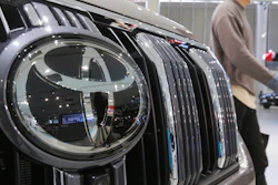 A visitor walks by a Toyota car displayed at a Toyota Motor Corp. showroom.