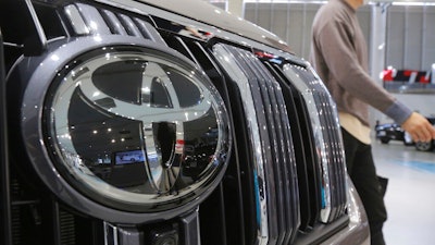 A visitor walks by a Toyota car displayed at a Toyota Motor Corp. showroom.