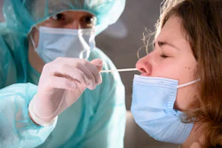 A health worker collects a nose swab sample for a polymerase chain reaction test at the Mycorama coronavirus testing facility, Cernier, Switzerland, Nov. 3, 2020.
