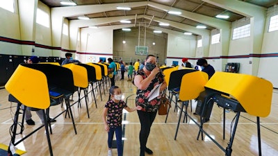 East Los Angeles voter Laura Cortez, 54, with her granddaughter Daniela 6, walk after casting her ballot in-person on Election Day.