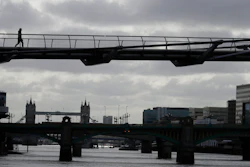 A pedestrian walks across the Millennium Bridge in London, May 11, 2020.