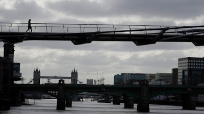 A pedestrian walks across the Millennium Bridge in London, May 11, 2020.