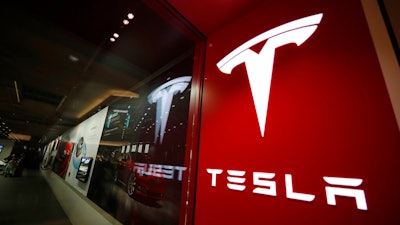 A sign bearing the company logo stands outside a Tesla store in Cherry Creek Mall in Denver.