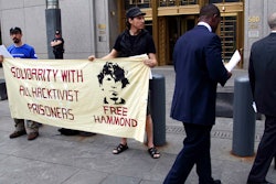 Protesters stand in front of the federal courthouse during the arraignment of hacker Jeremy Hammond, New York, May 14, 2012.