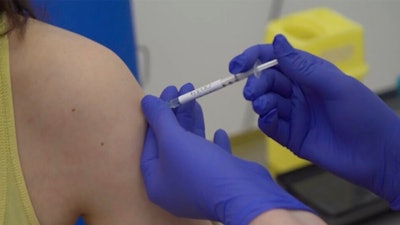 A person being injected as part of the first human trials in the UK to test a potential coronavirus vaccine, April 23, 2020.