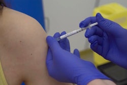 A person being injected as part of the first human trials in the UK to test a potential coronavirus vaccine.