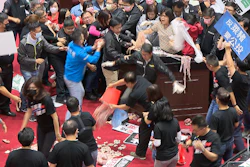 In this image made from video, lawmakers fight during a parliament session in Taipei, Taiwan on Friday, Nov. 27.