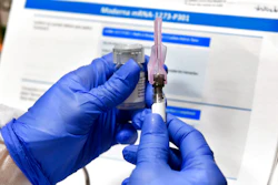 Nurse Kathe Olmstead prepares a shot that is part of a possible COVID-19 vaccine.