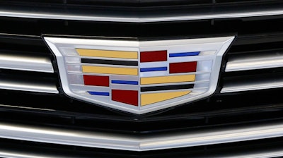 This Thursday, Feb. 11, 2016, file photo shows the Cadillac logo, a General Motors Co. brand, on display on a vehicle at the Pittsburgh International Auto Show in Pittsburgh. The U.S. government’s road safety agency on Wednesday, Nov. 11, 2020, is investigating complaints that the rear suspensions on older Cadillac SUVs can fail, causing drivers to lose control and possibly crash. The probe by the National Highway Traffic Safety Administration covers about 344,000 SUVs from 2010 through 2015.
